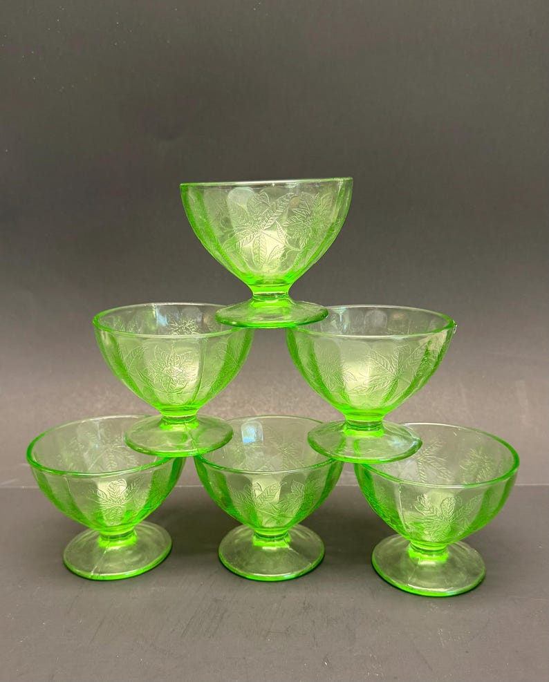 Puede incluir: Un conjunto de seis cuencos de postre de vidrio verde lima vibrante dispuestos en forma de pir&aacute;mide. Cada cuenco cuenta con una base de pedestal y un delicado patr&oacute;n en relieve de hojas y flores en la superficie exterior del vidrio transl&uacute;cido.