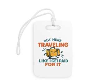 Op de afbeelding: Witte bagagelabel met een touwtje, met de tekst "OUT HERE TRAVELING LIKE I GET PAID FOR IT". Het label heeft een cartoonafbeelding van een gele koffer met een lachend gezicht en benen.