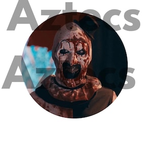 May include: A circular image features a menacing clown with white face paint, blood-red accents, and a small black top hat. The clown's expression is unsettling, with a dark, gaping mouth and intense eyes. The word "Aztecs" is partially visible in the background.