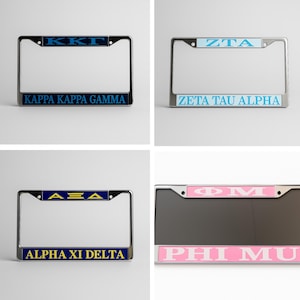 Peut inclure: Quatre cadres de plaques d'immatriculation avec des lettres grecques. Le cadre supérieur gauche affiche "KKG" en bleu et "KAPPA KAPPA GAMMA" en dessous. Le cadre supérieur droit affiche "ZTA" en bleu et "ZETA TAU ALPHA" en dessous. Le cadre inférieur gauche affiche "ΑΞΔ" en bleu et "ALPHA XI DELTA" en dessous. Le cadre inférieur droit affiche "ΦΜ" en rose et "PHI MU" en dessous.