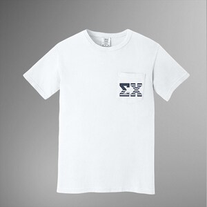 Op de afbeelding: Wit T-shirt met korte mouwen en een borstzak. De zak heeft een marineblauw en wit ontwerp van de Griekse letters Sigma en Xi. Het shirt heeft een ronde hals en een label bij de halslijn.