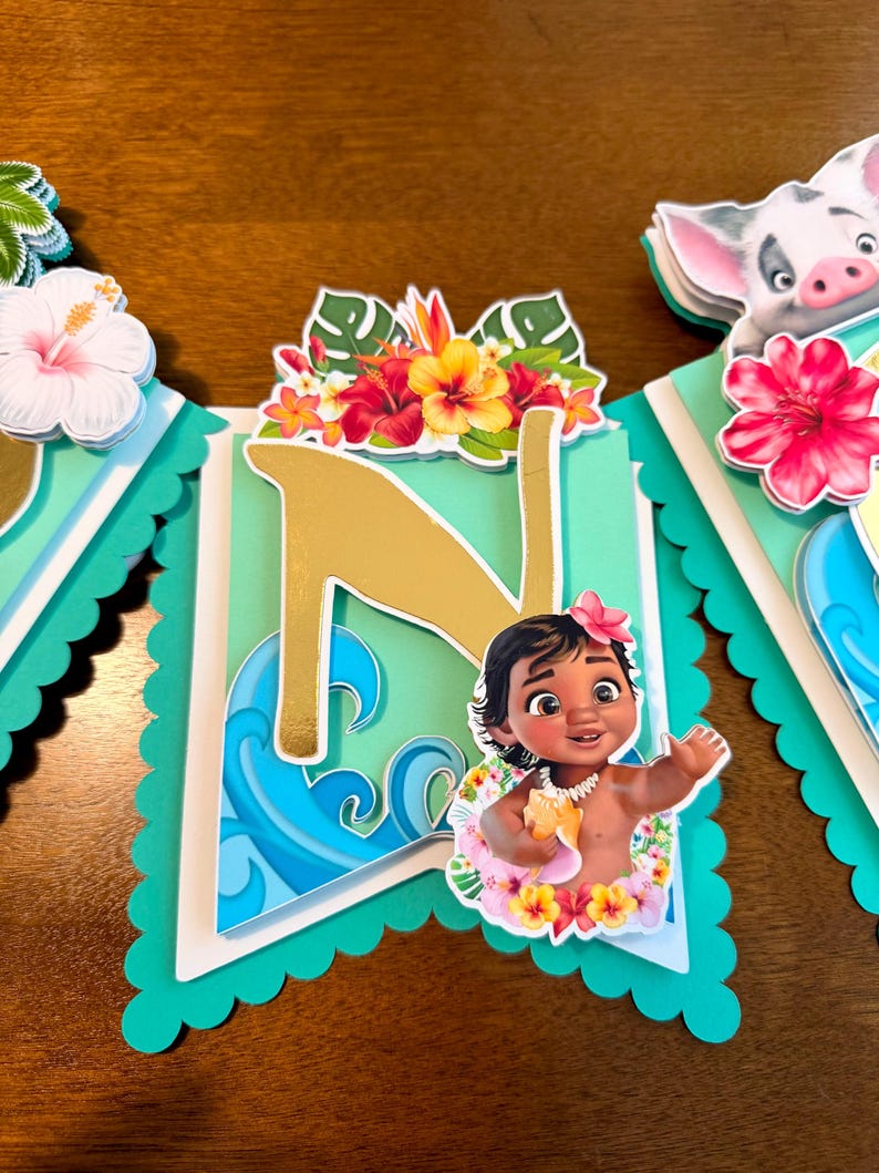 May include: A banner with a teal scalloped edge, featuring a gold letter "N" and a cartoon image of a baby girl with a flower crown. The banner is decorated with tropical flowers and ocean wave designs.