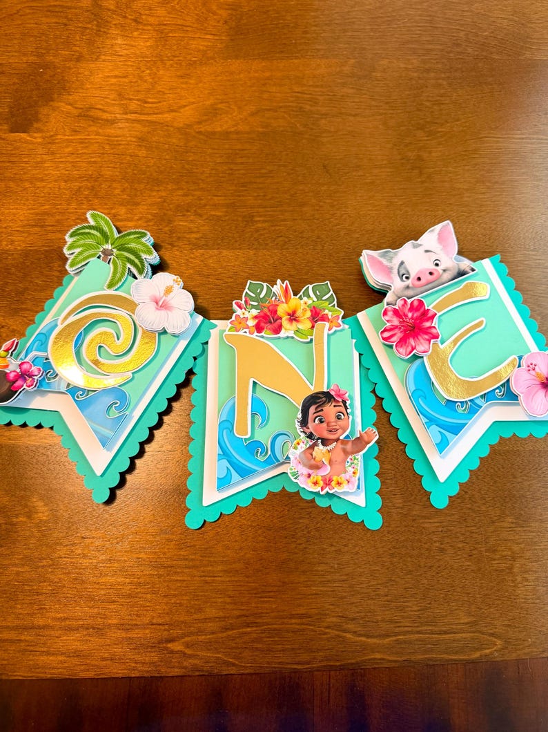 May include: A banner with three pennants featuring a tropical theme. Each pennant has a teal background with gold lettering and tropical flowers. The banner includes images of a palm tree, a pig, and a young girl.