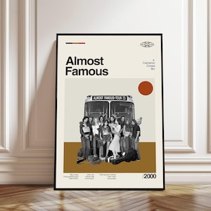 以下が含まれることがあります： 映画「Almost Famous」のフレーム入りポスター。ツアーバスの前に立つ人々のグループが描かれています。ポスターはベージュの背景に、映画のタイトルが太字の黒い文字で、茶色のアクセントが付いています。