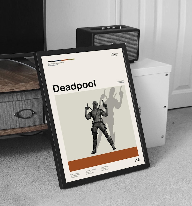 Puede incluir: Un p&oacute;ster enmarcado con la palabra "Deadpool" en negro. El p&oacute;ster muestra una ilustraci&oacute;n estilizada del personaje de Deadpool sosteniendo dos pistolas, con una sombra del personaje detr&aacute;s de &eacute;l. El fondo es crema con una franja marr&oacute;n en la parte inferior.