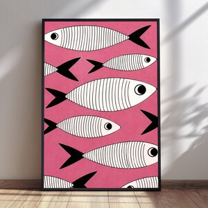 May include: A rectangular framed wall art print featuring a vibrant pink background populated by multiple stylized white fish. Each fish has black vertical line detailing on its body, a solid black tail, and a prominent black and white circular eye.