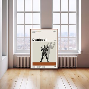 Puede incluir: Un p&oacute;ster enmarcado con la palabra "Deadpool" en negro. El p&oacute;ster presenta una ilustraci&oacute;n en blanco y negro de Deadpool sosteniendo armas sobre un fondo beige. El p&oacute;ster se exhibe en una habitaci&oacute;n con una ventana y suelo de madera.