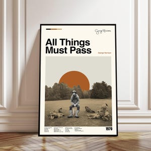 Puede incluir: Un póster enmarcado con la portada del álbum "All Things Must Pass" de George Harrison. La obra de arte incluye una imagen en tonos sepia de Harrison, un gran sol naranja y el título del álbum en texto negro en negrita. También se muestra el año 1970.