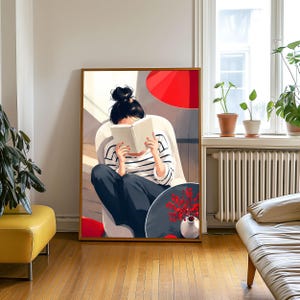 Puede incluir: Una impresión de arte mural enmarcada que representa a una persona con cabello oscuro recogido en un moño, vistiendo una camisa de rayas blancas y negras de manga larga y pantalones oscuros, sentada en una silla mientras lee un libro blanco.