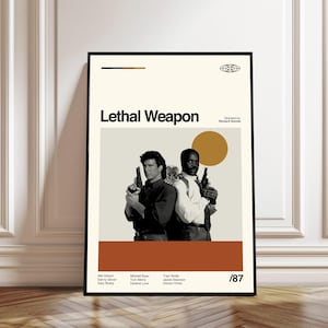 May include: A framed movie poster for "Lethal Weapon" featuring Mel Gibson and Danny Glover. The poster has a beige background with the title in bold black letters. The actors are holding guns. The poster has a brown stripe at the bottom and the number /87.