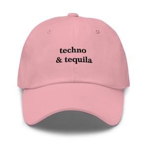 May include: A pale pink baseball cap featuring the text "techno & tequila" in black. The cap has a curved peak and a button on top. A casual accessory for music and drinks lovers.