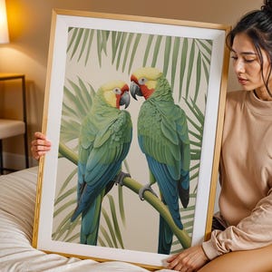 May include: A framed art print depicting two vibrant parrots on a branch, with a backdrop of palm leaves. The parrots display green, blue, yellow, and red feathers. The artwork is presented in a gold frame.