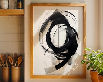 May include: Abstract black and white artwork in a wooden frame. The painting features bold brushstrokes and circular shapes. The artwork is displayed on a wooden countertop near a window with potted plants.