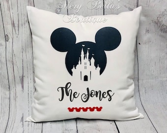 May include: White square pillow featuring a black silhouette of Mickey Mouse ears and a castle design. The text "The Jones" is below the castle, with red Mickey Mouse head icons at the bottom.