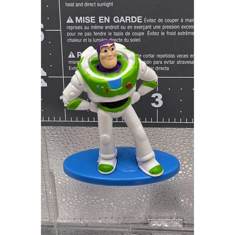 Mini figura di Buzz Lightyear di Toy Story della Mattel, base ovale blu, mani sui fianchi allentate immagine 1