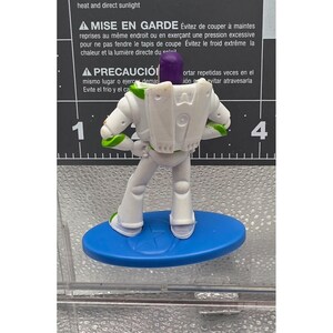 Mini figura di Buzz Lightyear di Toy Story della Mattel, base ovale blu, mani sui fianchi allentate immagine 2