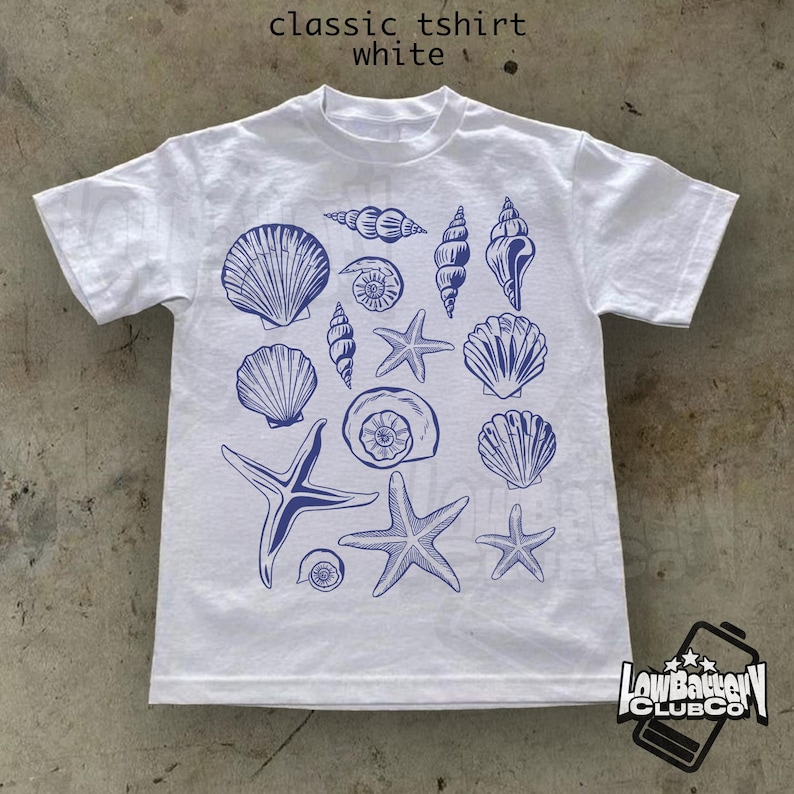 May include: White classic t-shirt with a blue seashell and starfish design. The shirt features various seashell illustrations and starfish. The text "classic tshirt white" is at the top.
