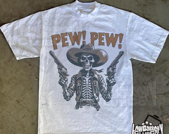 Camiseta gráfica Cowboy Pew Pew, divertida camiseta de rodeo western, camiseta retro countrycore con colores cómodos, ropa urbana con estética del lejano oeste.