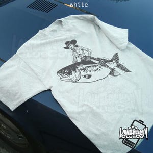 Grappige cowgirl vis T-shirt, eigenzinnig shirt met westerse humor, vintage rodeo vis grafisch T-shirt, comfortabele kleuren dierlijke esthetiek