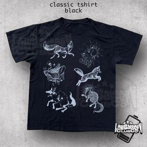 May include: Black classic t-shirt with white illustrations of foxes and other creatures. The shirt has a crew neck and short sleeves. The text "classic tshirt black" is at the top of the image.