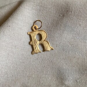 18k Goldcharme. Schöner Buchstabe R Anhänger mit eleganten Details.