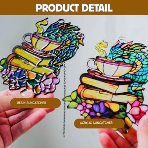 May include: Two resin and acrylic suncatchers. Each features a dragon perched atop a stack of books with a teacup. The dragon is multi-colored, with green, blue, and yellow scales. The books are yellow and the flowers are pink and purple.