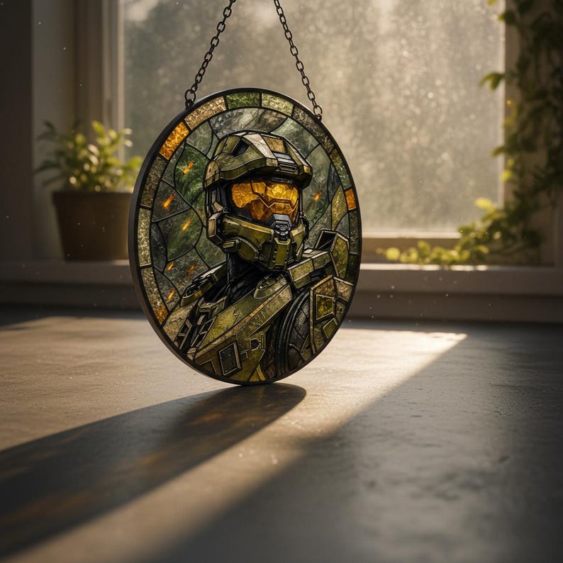 May include: Circular stained glass panel depicting a character in green and gold armour. The artwork is suspended by a chain. The panel is set against a window with natural light.