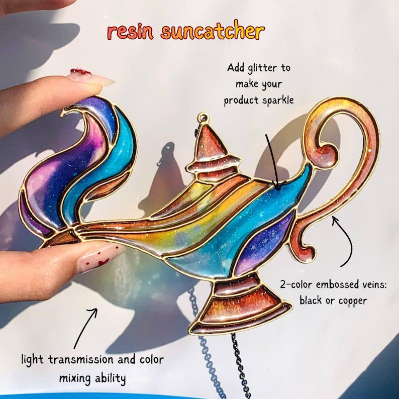 May include: A colorful resin suncatcher in the shape of a genie lamp. The lamp features a rainbow of colors, including blue, purple, yellow, and orange, with gold-colored trim. The text "resin suncatcher" is at the top.