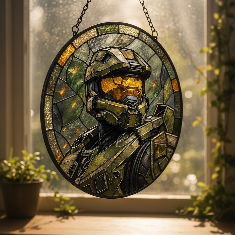 May include: A circular stained glass panel featuring a character in green and gold armour. The artwork is framed in black and suspended by a chain. The background shows a window with a blurred view of foliage.