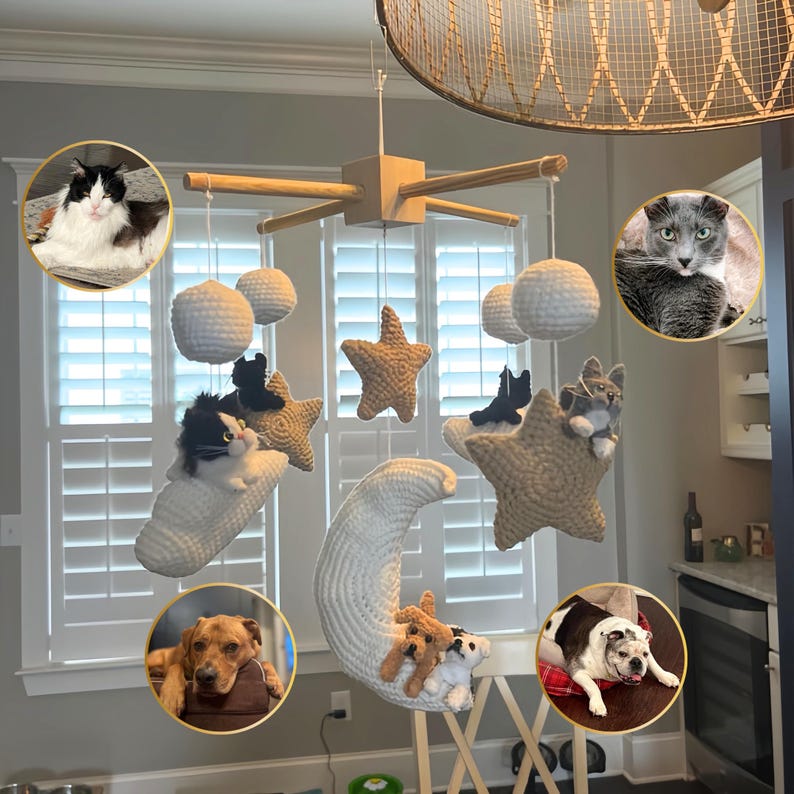 Puede incluir: Un m&oacute;vil colgante con un marco de madera en forma de cruz y elementos de ganchillo suspendidos, incluyendo una gran luna creciente blanca, estrellas beige, esferas blancas y peque&ntilde;as figuras de peluche.