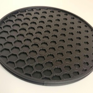 May include: A black round honeycomb-shaped diffuser for photography lighting.