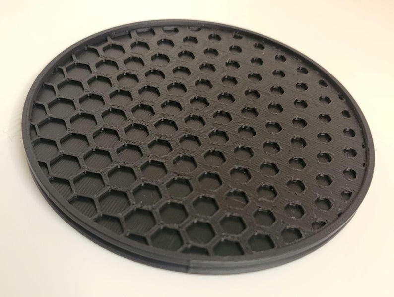 May include: A black round honeycomb-shaped diffuser for photography lighting.