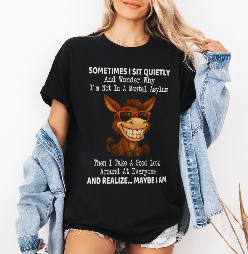 Puede incluir: Camiseta negra con el texto "SOMETIMES I SIT QUIETLY And Wonder Why I'm Not In A Mental Asylum Then I Take A Good Look Around At Everyone AND REALIZE... MAYBE I AM." La camiseta presenta un burro de dibujos animados con gafas de sol.