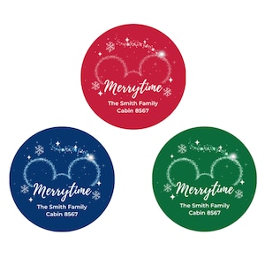 May include: Three circular stickers in red, blue, and green. Each features a white glittery mouse ear outline, snowflakes, and stars. The text reads Merrytime, The Smith Family, and Cabin 8567 in a white script and sans-serif font.