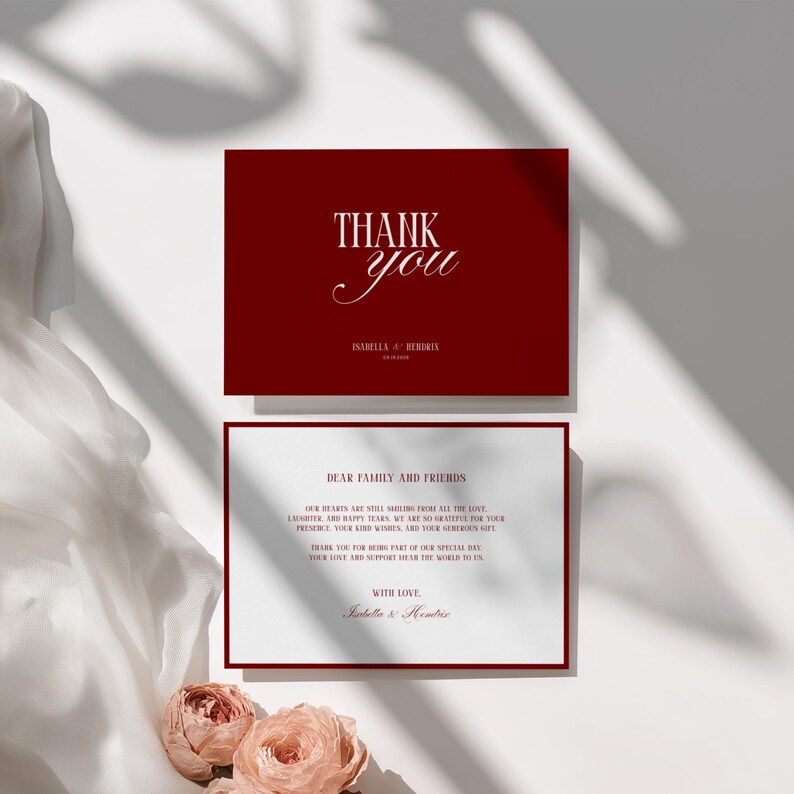 May include: A set of burgundy thank you cards with white text. The top card reads "THANK you" with a couple's names and date. The bottom card has a message to family and friends, with the couple's names at the bottom.