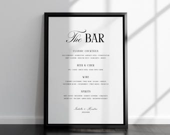 May include: A framed black and white bar menu with the title "The BAR" in elegant script. The menu lists classic cocktails, beer & cider, wine, and spirits. The bottom of the menu includes a name and date.