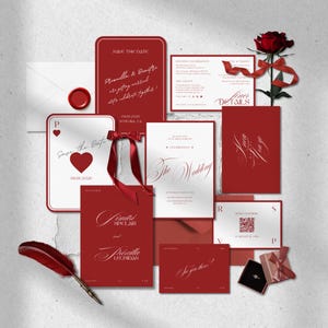 May include: A collection of red and white wedding stationery, including invitations, save-the-date cards, and an envelope with a wax seal. A red rose with a ribbon and a quill pen are also included.