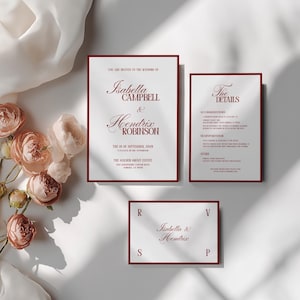 May include: Wedding invitation suite featuring a main invitation, details card, and RSVP card. The text is in a burgundy color with a serif font. The main invitation reads "Isabella Campbell & Hendrix Robinson". The suite is on a white background.