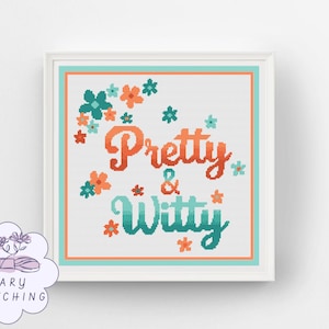 Op de afbeelding: Een ingelijst kruissteekwerk met de woorden "Pretty & Witty" in oranje en teal. Het ontwerp bevat bloemmotieven in teal en oranje, tegen een witte achtergrond. De lijst is wit met een teal en oranje rand. Het Mary Stitching logo staat linksonder.