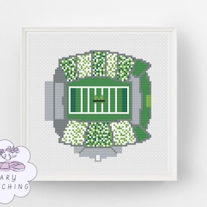 May include: A cross-stitch pattern featuring an aerial view of a football stadium with a green field, white yard lines, and gray seating sections. The design includes a logo in the corner with the text MARY STITCHING and a floral illustration.