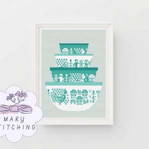 以下が含まれることがあります： ターコイズと白の模様のミキシングボウルのスタックが特徴の額入りプリント。各ボウルは異なるフォークアートのデザインを示しています。プリントは淡い緑色の背景に設定されています。クロスステッチのデザインです。