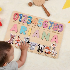 Peut inclure: Puzzle éducatif en bois avec le nom "ARIANA" et les chiffres 0 à 9 de différentes couleurs. Comprend des illustrations d'animaux comme un kangourou, un tigre, un zèbre, un koala, un panda, un renard et une girafe. Le tableau est sur une surface claire.