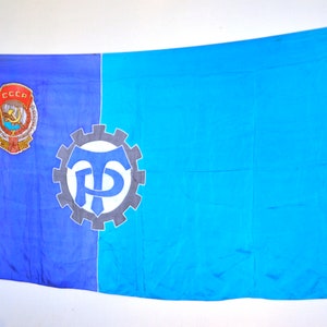 May include: A blue and turquoise flag with a gear-shaped symbol and the text "CCCP" in a red circle.