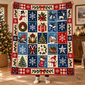 May include: A rectangular Christmas-themed throw blanket featuring a grid of festive illustrations including snowmen, snowflakes, a reindeer, a decorated tree, a lantern, a gift box, a bird, a stocking, and a cabin on a blue and red background.