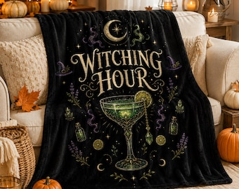 Könnte beinhalten: Eine schwarze Fleecedecke mit einer zentralen Grafik eines grünen Cocktails in einem Stielglas, umgeben von Illustrationen einer Mondsichel, kleinen Glasflaschen, Lavendelzweigen und dem Schriftzug Witching Hour in goldener Farbe.