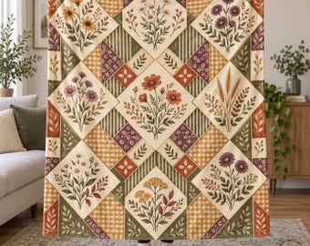 May include: A large rectangular throw blanket featuring a patchwork design of diamond-shaped panels. Each panel displays botanical illustrations of various wildflowers, wheat stalks, and foliage in shades of orange, yellow, purple, and green.