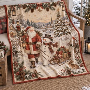 May include: A cream-colored throw blanket featuring a festive winter scene with Santa Claus holding a lantern, a snowman pulling a wooden sled filled with wrapped gifts, a decorated Christmas tree, pine branches, and a rabbit.