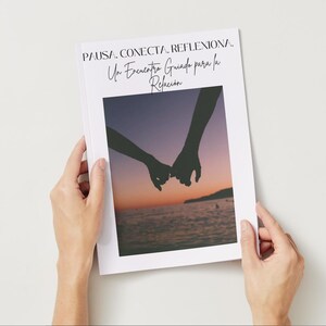 May include: A white book with the title "PAUSA. CONECTA. REFLEXIONA. Un Encuentro Guiado para la Relación" in black script. The cover features a photo of two hands holding pinky fingers against a sunset backdrop.
