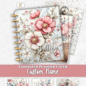 May include: A laminated planner cover featuring a floral design with pink and white flowers, green leaves, and a custom name Jillian in white script. The cover includes gold disc binding rings and additional designs showing a fan and a pocket watch.