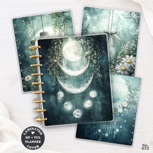 May include: A set of laminated planner covers featuring dark teal and green botanical illustrations with hanging moon phases, stars, and white daisy flowers. The covers have gold-colored disc-bound spine rings and a circular black label with white text.
